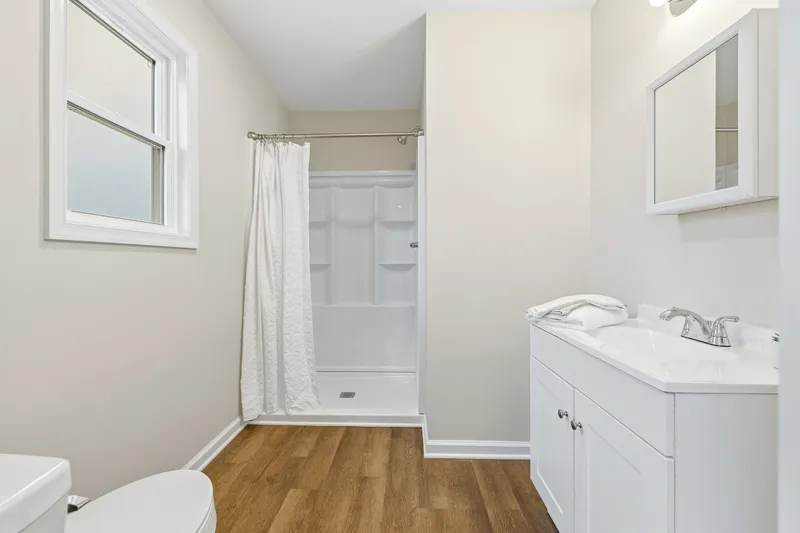 Primary ensuite bathroom with single shower and white shaker vanity