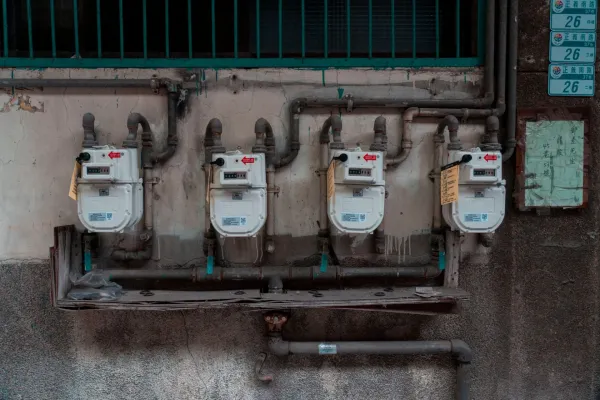 Four gas meters mounted on an exterior wall.